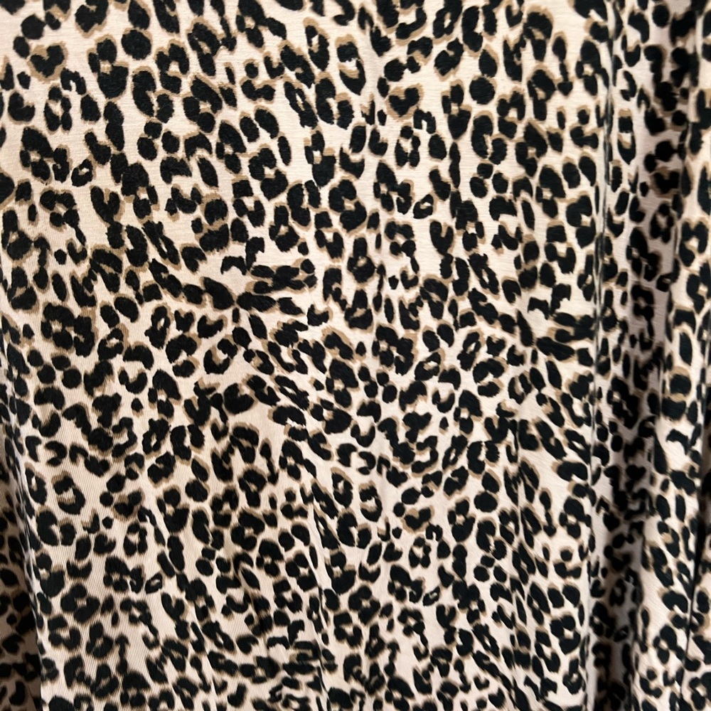 Tan and black animal print dress with crisscross strap detail.
